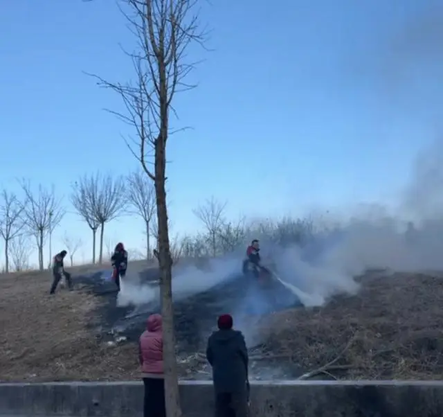 草坡突發(fā)火情，5名快遞小哥拎著滅火器沖了上去